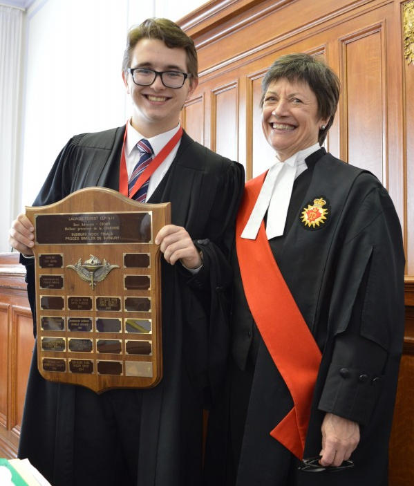 Rudi and Justice Hennessey holding award plaque.