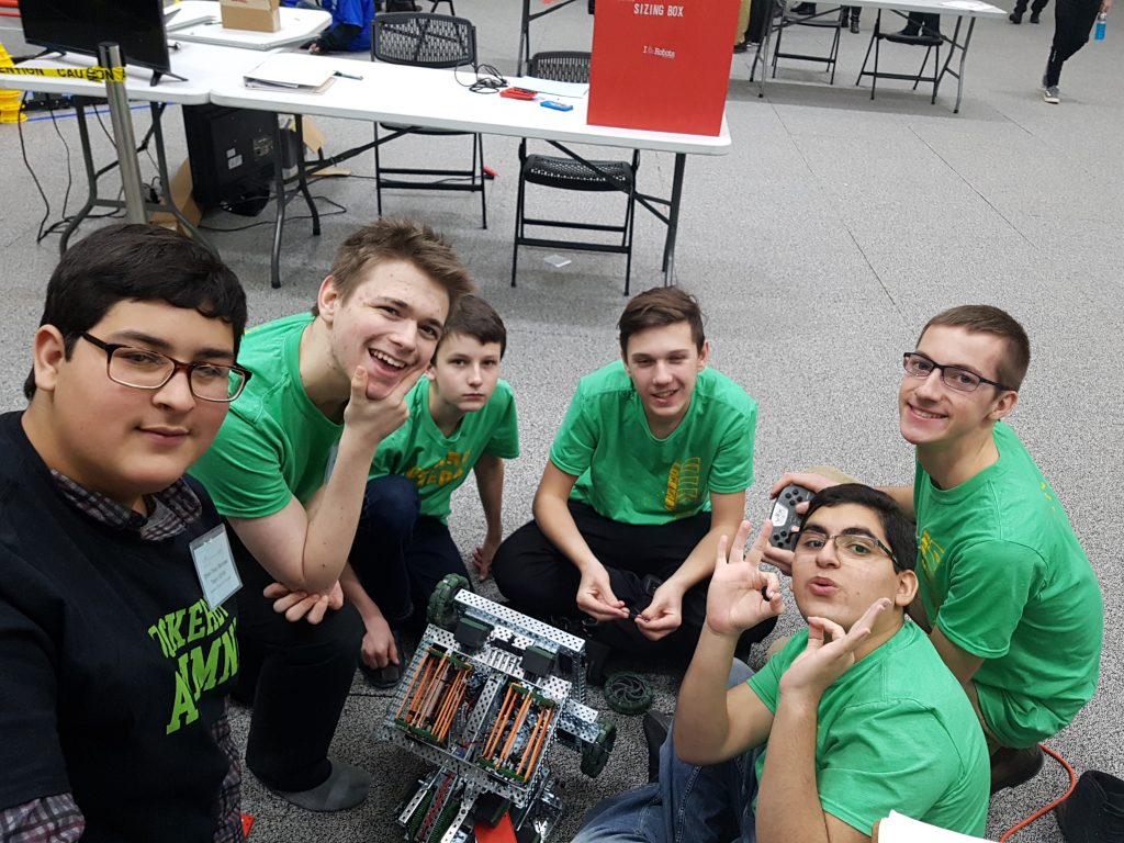 students posing for a picture with their robot
