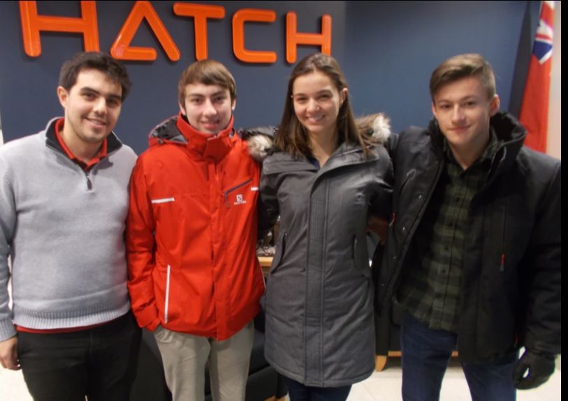 Four students in front of Hatch sign.